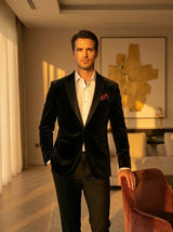 איש מחייך בחליפת כהה וחולצה בהירה מציג צמיד כסף אלגנטי, מתנות אישיות לגברים