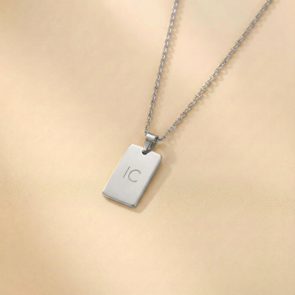 שרשרת מלבנית עם חריטה על האות הראשונה של השם